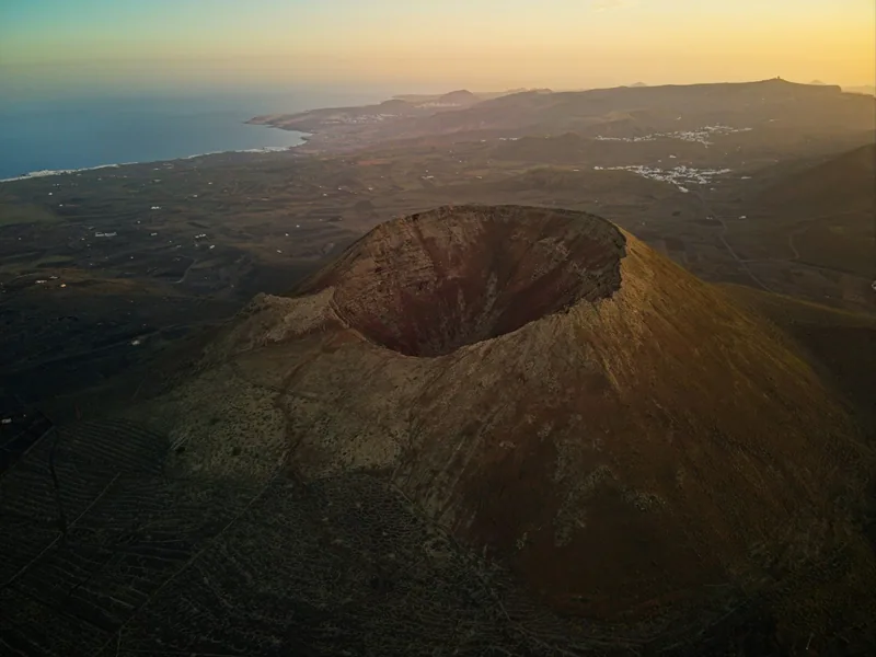 Vulkankrater och kustlandskap på Lanzarote i lågt kvällsljus