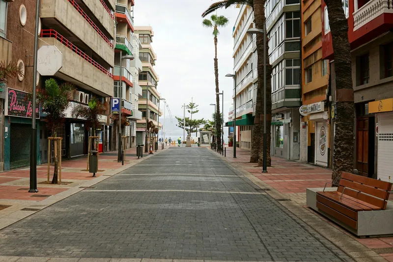 Butiksgata kantad av palmer i ett turistområde på Gran Canaria