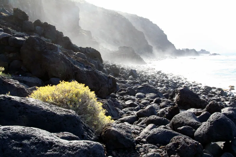 Svarta lavablock och havsdis vid Charco Azul på El Hierro